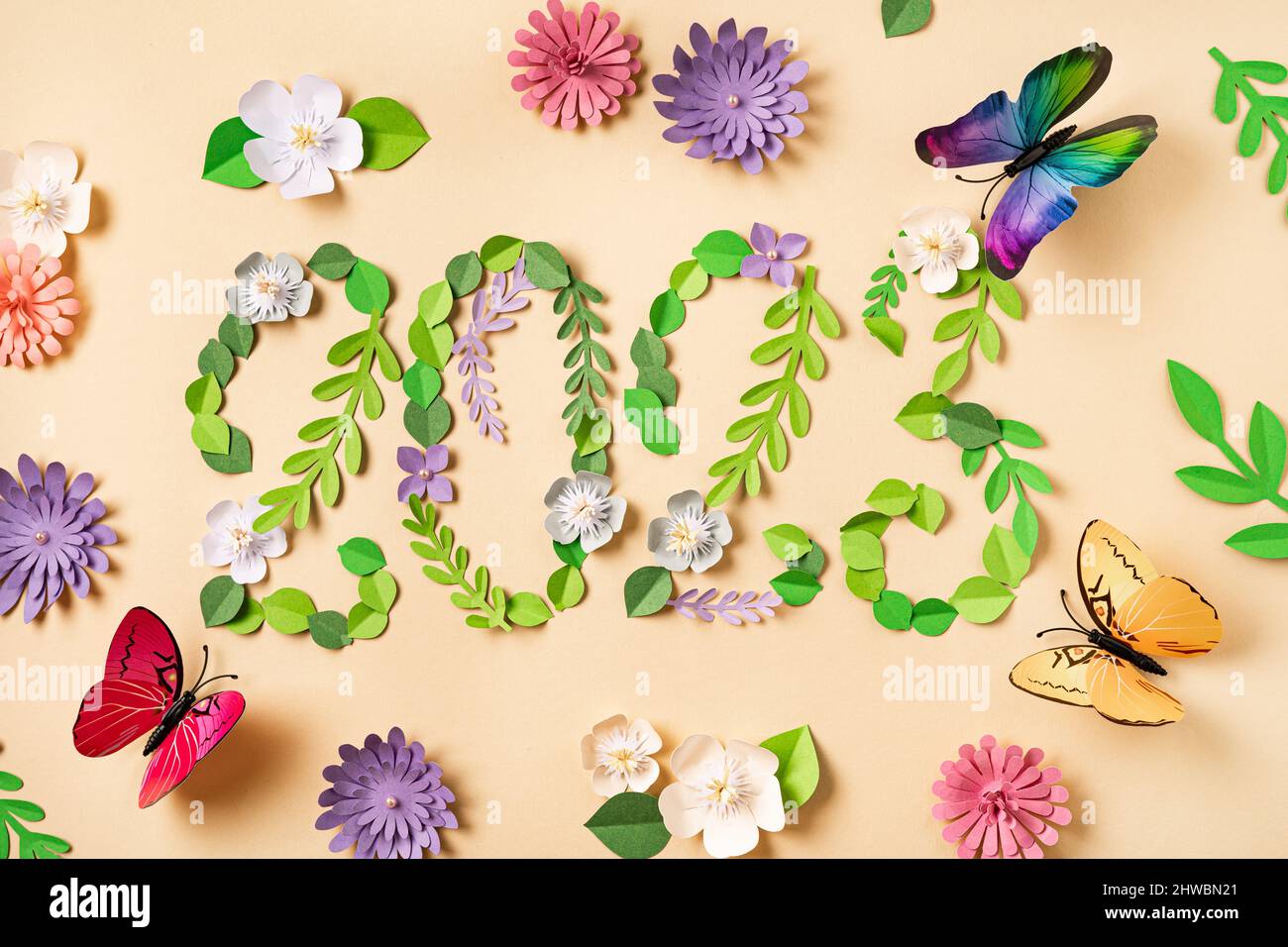 2023 nombre fait à partir de fleurs et de feuilles de papier. De beaux papillons volent. Conception d'art en papier. Fond floral naturel Banque D'Images