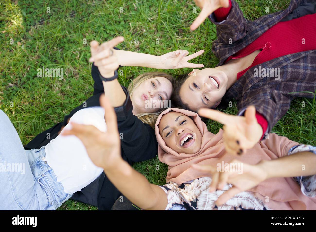 Joyeux femmes diverses couché sur la pelouse Banque D'Images