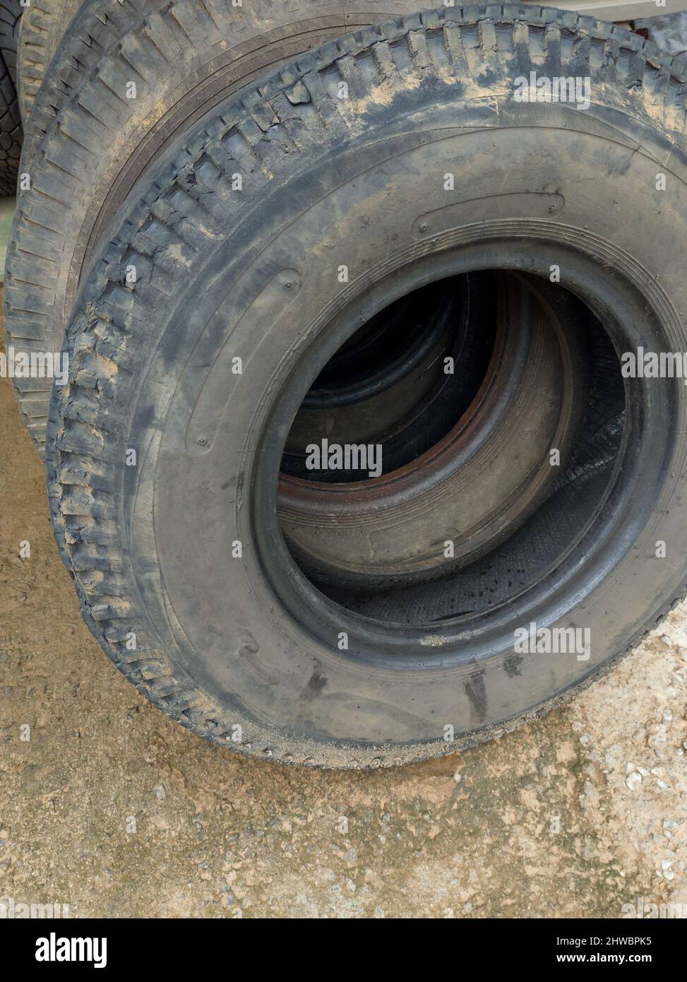 vieux pneus de camion empilés dans un atelier de réparation, gros plan Banque D'Images