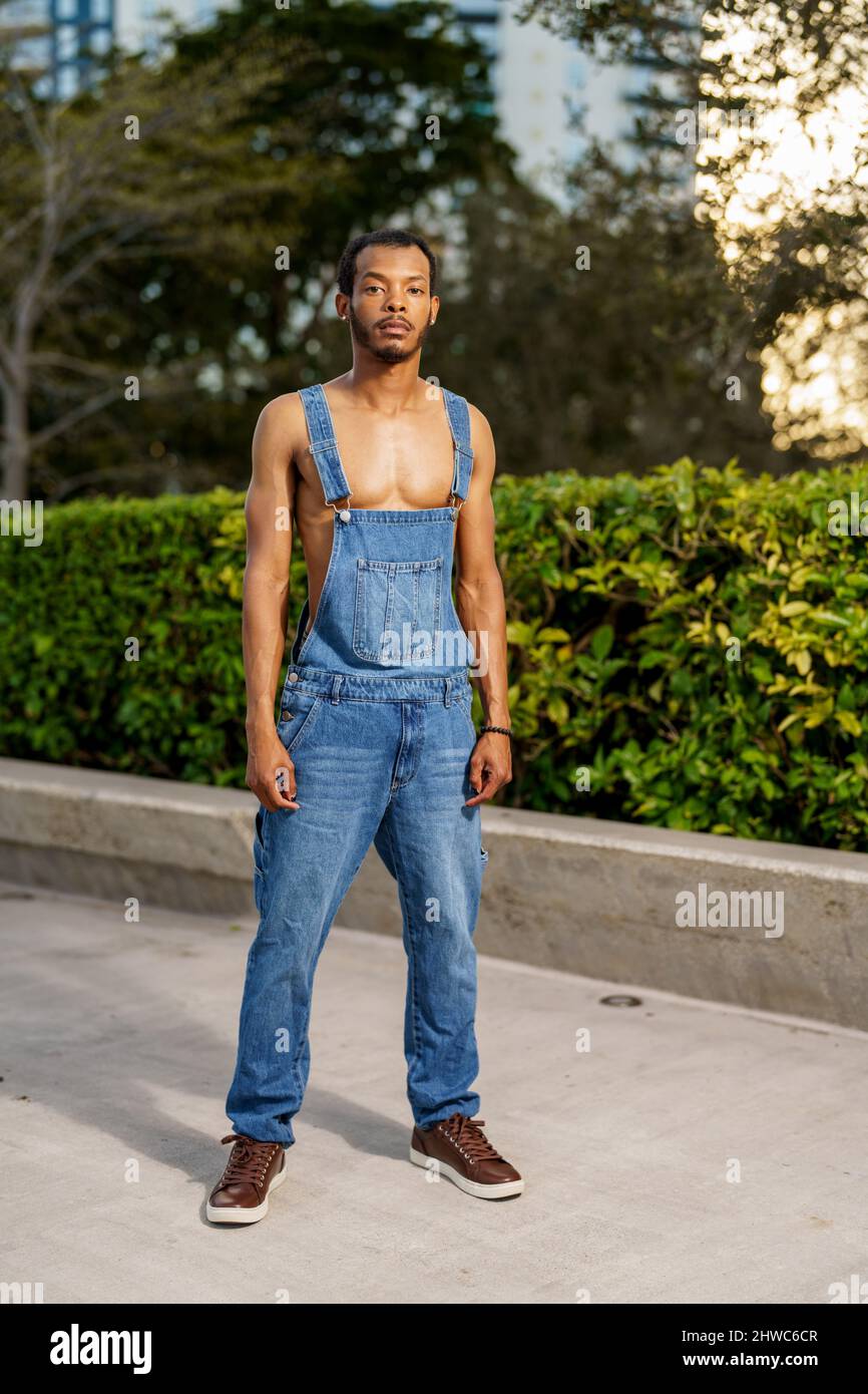 Beau jeune homme noir posant dans des salopettes dans le parc Photo Stock -  Alamy