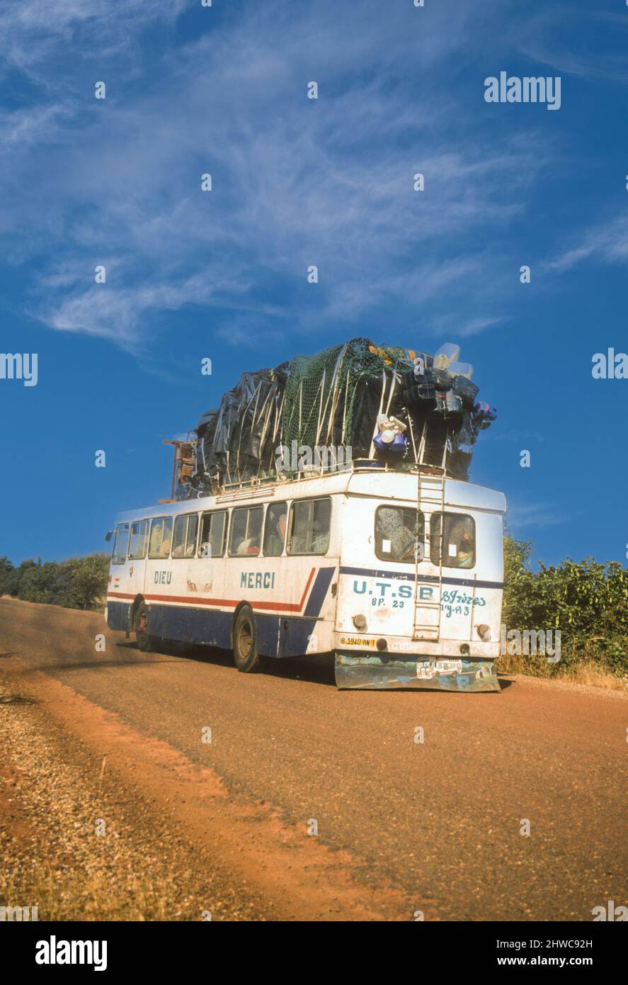 Bus longue distance sur la route de Ouagadougou, Burkina Faso, à Niamey, Niger. "Dieu merci" écrit sur le côté (Dieu Merci). Photographié en novembre 1998. Banque D'Images