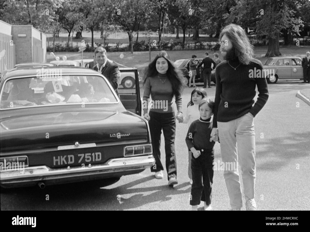 John Lennon et Yoko Ono saluent les fans près de leur domicile à Surrey avant un voyage à Durness, en Écosse, dans leur Austin Maxi avec son fils Julian et sa fille Kyoko. Malheureusement, le voyage s'est terminé à 40 miles de Durness dans un fossé près de la langue. John conduisait sur une route à une seule voie et se balança pour éviter qu'un conducteur allemand confus ne se renporte dans l'autre sens. Ils ont passé cinq jours dans un hôpital local en rétablissement.27th juin 1969. Banque D'Images