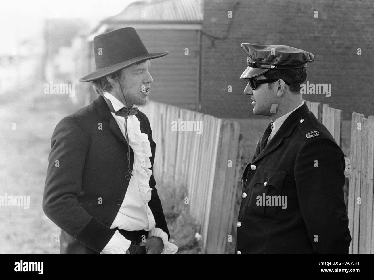 Mick Jagger, chanteur de Rolling Stones, qui joue le rôle principal dans le film Ned Kelly, s'entretient avec le responsable Harold Oxley du Forcet de la police de Nouvelle-Galles du Sud lors d'une pause dans le tournage à Bugendore, en Australie. Oxley a été affecté à l'unité de film pendant la prise de vue. Juillet 1969. Banque D'Images