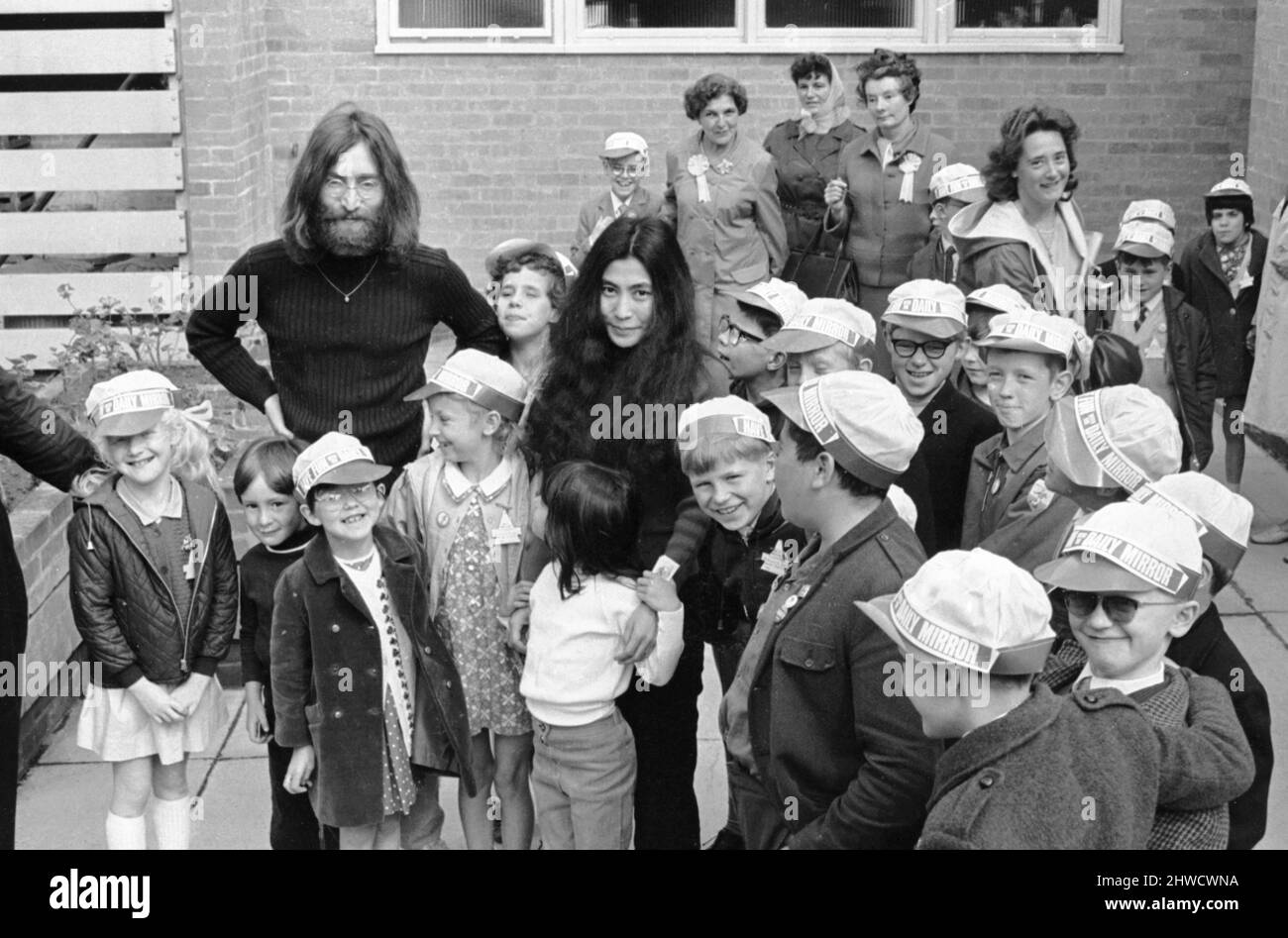 John Lennon et Yoko Ono saluent les fans près de leur domicile à Surrey avant un voyage à Durness, en Écosse, dans leur Austin Maxi avec son fils Julian et sa fille Kyoko. Malheureusement, le voyage s'est terminé à 40 miles de Durness dans un fossé près de la langue. John conduisait sur une route à une seule voie et se balança pour éviter qu'un conducteur allemand confus ne se renporte dans l'autre sens. Ils ont passé cinq jours dans un hôpital local en rétablissement.27th juin 1969. Banque D'Images