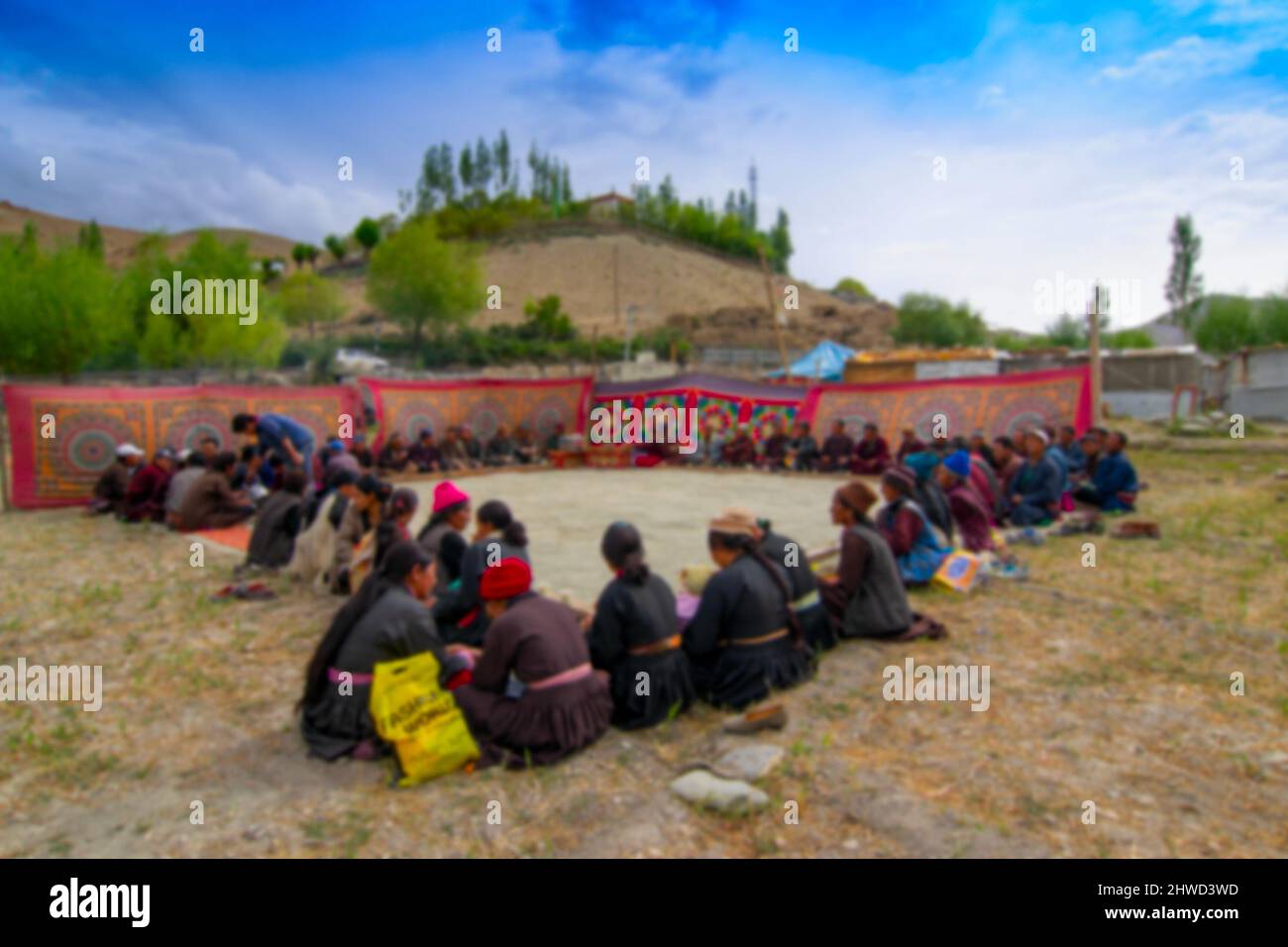 Image floue de Mulbekh, Ladakh, Inde. Ladakhi les gens dans les robes traditionnelles, réunis pour le festival religieux. Montagnes de l'Himalaya en arrière-plan Banque D'Images