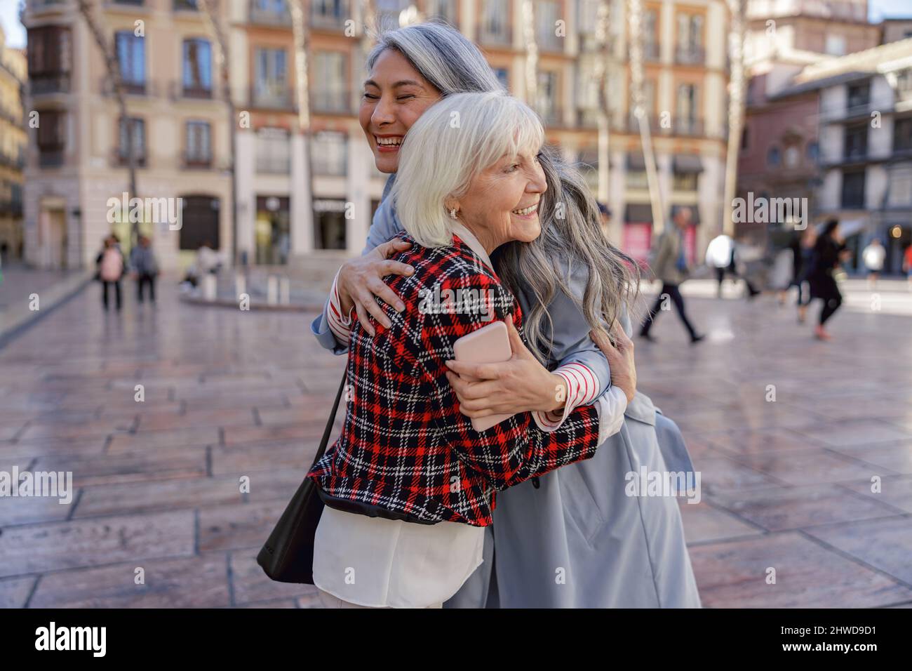 Des amies joyeuses se promener dans le centre-ville Banque D'Images