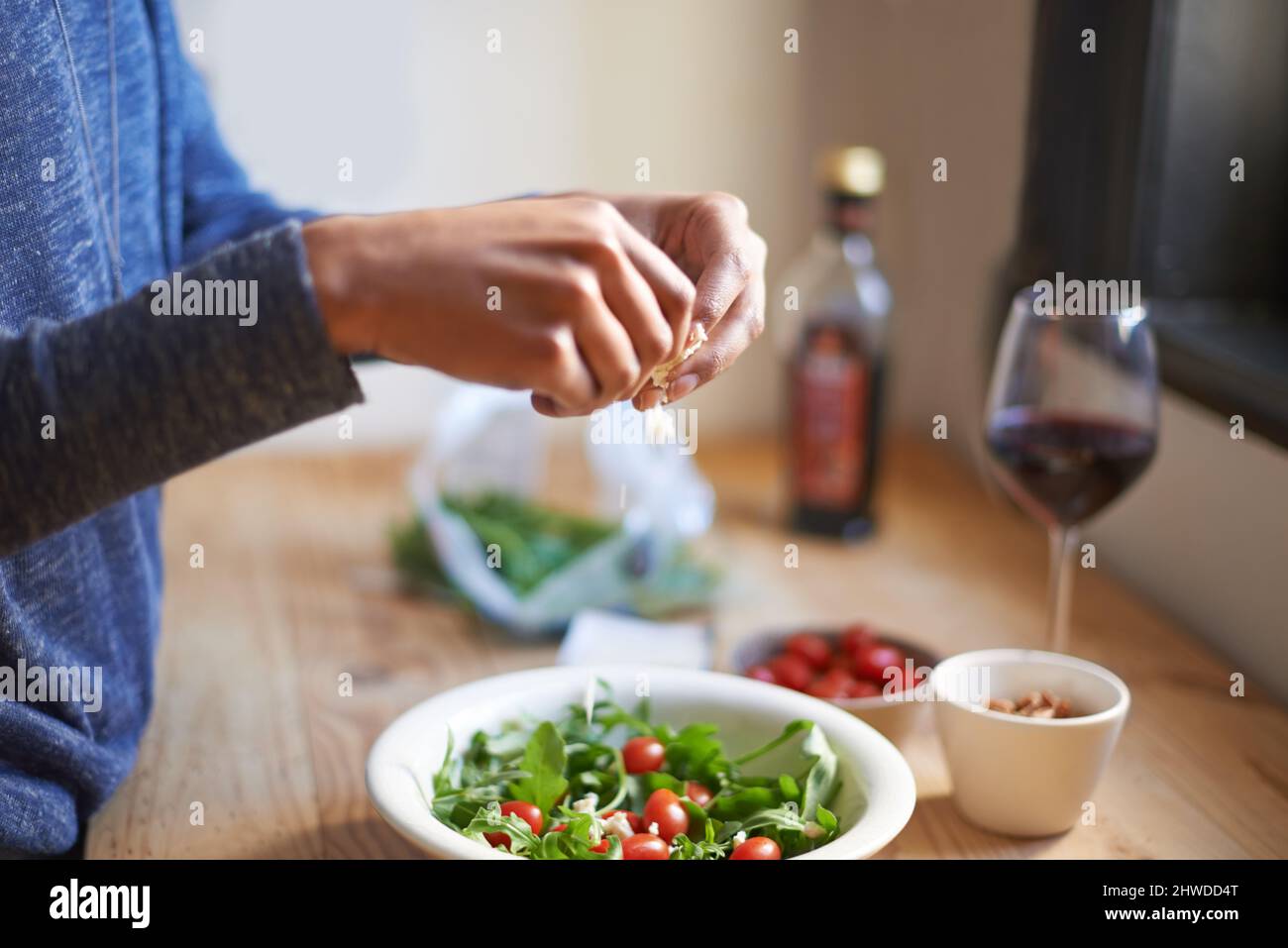 Pour un déjeuner parfait. Une jeune femme qui fait une salade dans sa cuisine. Banque D'Images