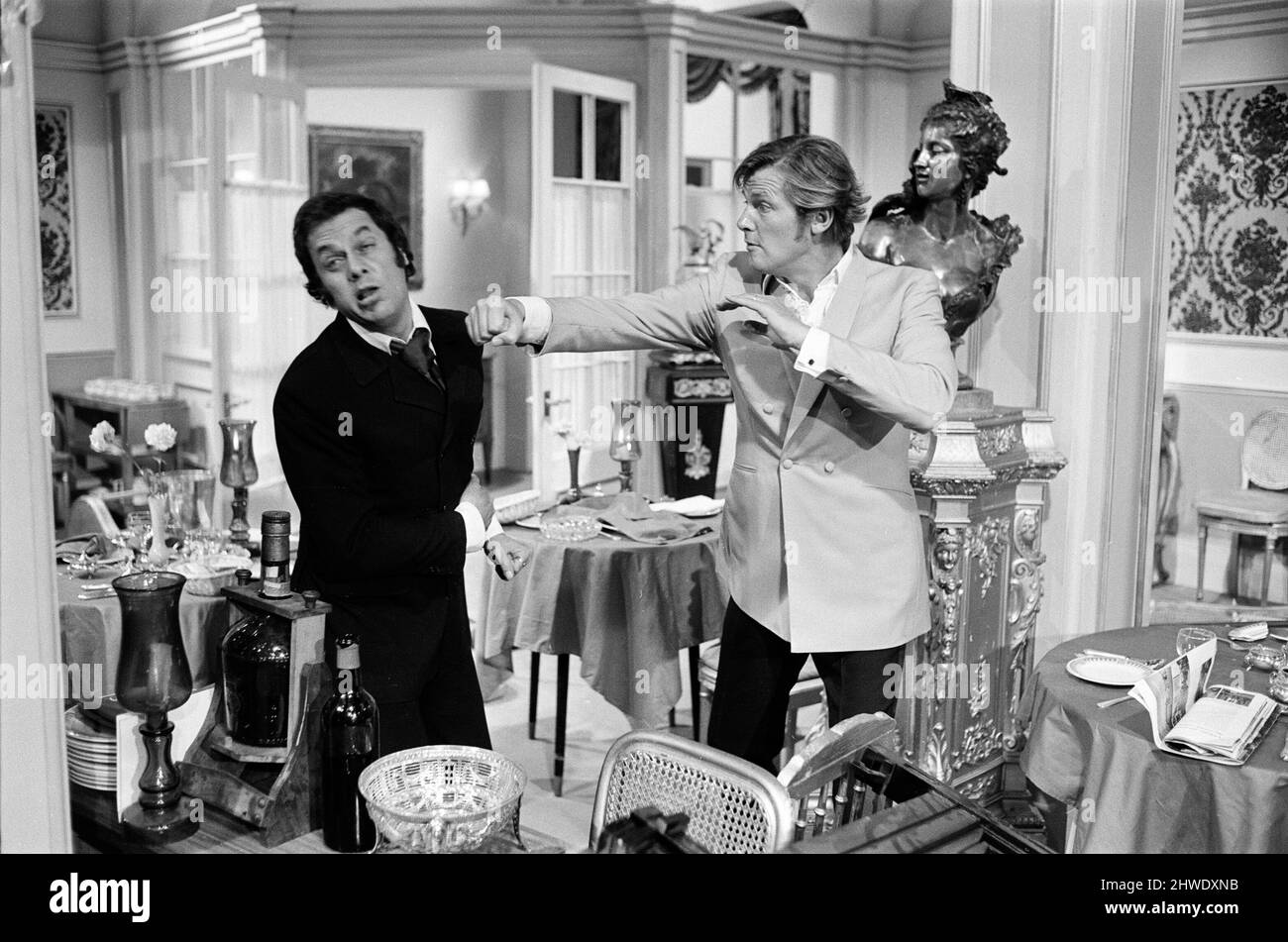 Roger Moore et Tony Curtis se battent les uns avec les autres sur l'ensemble des Persuaders! Aux Pinewood film Studios, Iver, Bucks. Roger joue un Seigneur anglais, qui rencontre Tony (jouant un millionnaire de Brooklyn brash) et dans cette séquence d'ouverture, ils ont un combat de course spectaculaire dans un restaurant. 11th août 1970. Banque D'Images