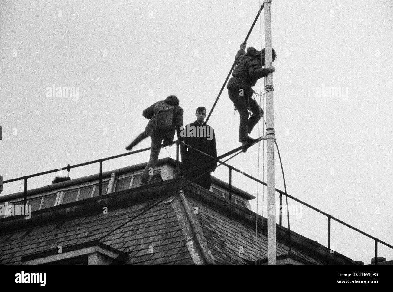 La scène sur le mât de la Rhodésie House en tant que policier regarde les deux hommes qui quittent le mât après la démonstration. Ils ont mis à l'échelle le bâtiment avec leur drapeau la nuit précédente et ont soulevé l'Union Jack à la place du drapeau de Rhodésie. Au cours de la journée, il y a eu une marche anti Rhodésie. 12th janvier 1969. Banque D'Images La scène sur le mât de la Rhodésie House en tant que policier regarde les deux hommes qui quittent le mât après la démonstration. Ils ont mis à l'échelle le bâtiment avec leur drapeau la nuit précédente et ont soulevé l'Union Jack à la place du drapeau de Rhodésie. Au cours de la journée, il y a eu une marche anti Rhodésie. 12th janvier 1969. Banque D'Images