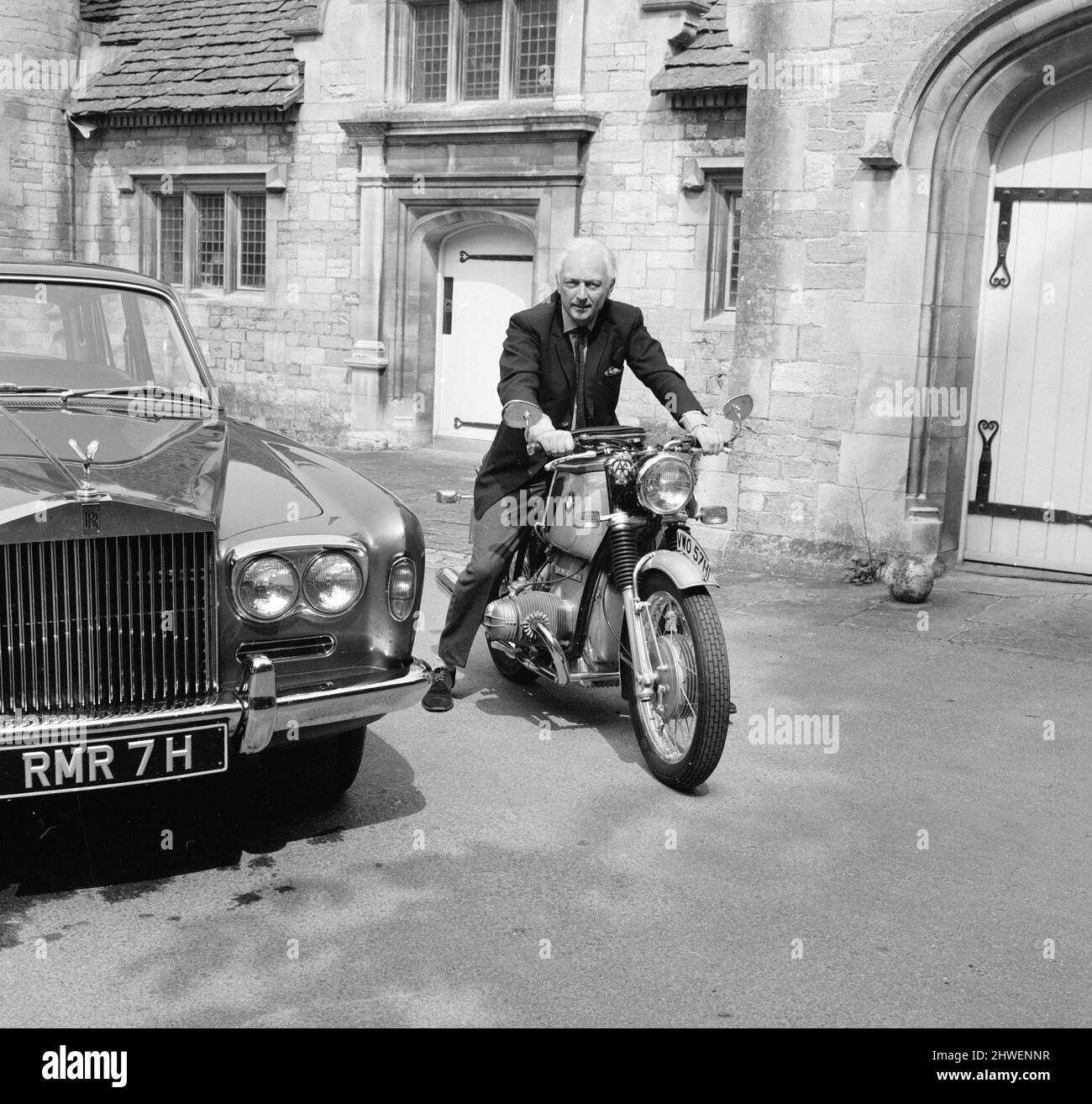 Dr. Alexander Eric Molton CBE (né le 9 avril 1920), alias Alex Molton, ingénieur et inventeur anglais, spécialisé dans la conception de suspension. Photographié assis sur une moto BMW, à côté de Rolls Royce dépasse sa maison à 'The Hall' à Bradford-on-Avon le 1970 août. Banque D'Images