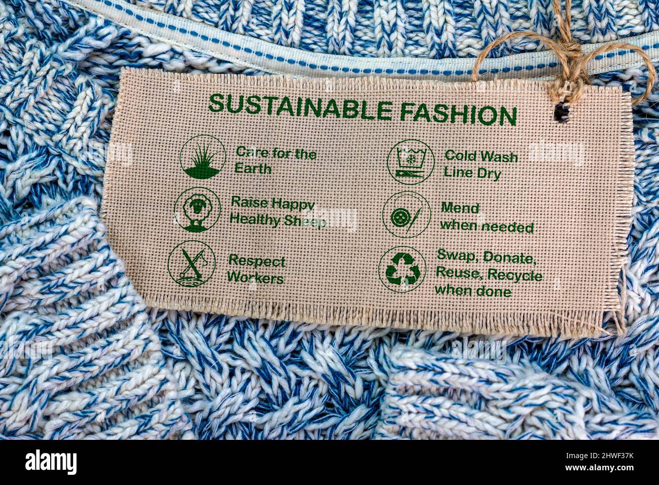 label de mode durable sur pull en laine avec icônes de soin et texte, consumérisme éthique Banque D'Images