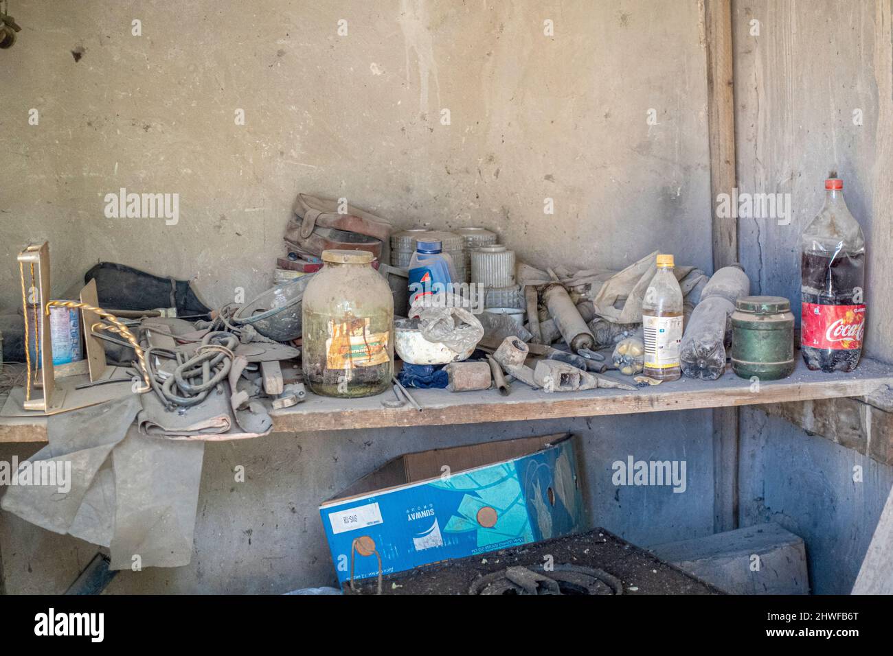 Étagère en bois encombrée et poussiéreuse dans la salle de stockage avec bouteilles en plastique sale inutilisées. Concept- ménage, couverture de l'album. Banque D'Images