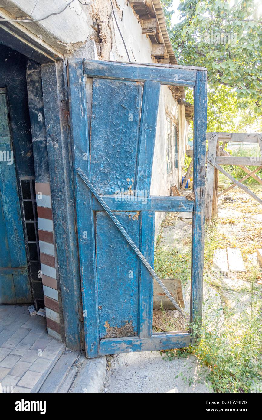 La vieille porte de la grange détruite par la désintégration avec de vieux panneaux en bois, des plaques ouvraient des vieilles portes de la grange cassées Banque D'Images