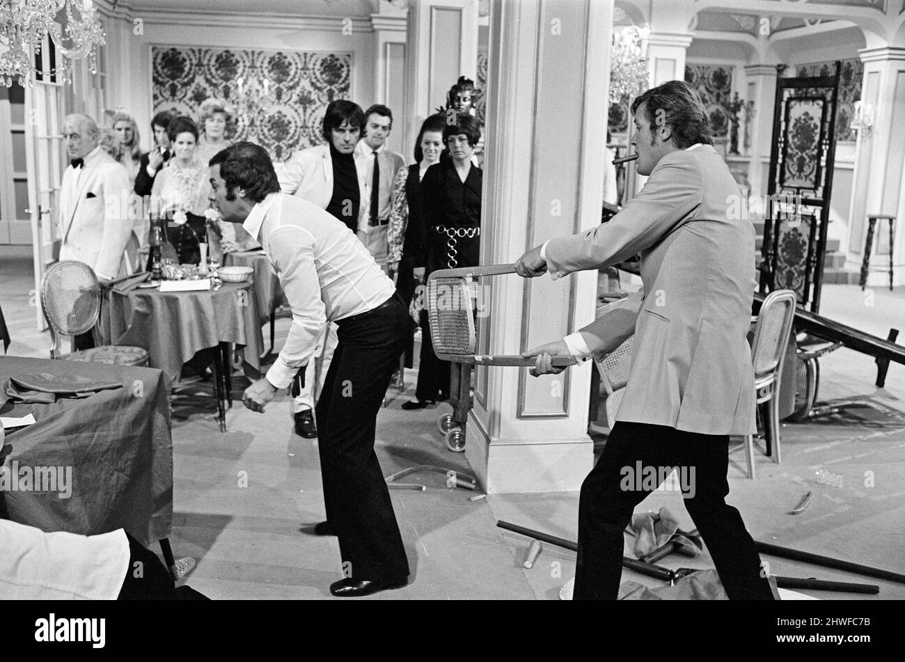 Roger Moore et Tony Curtis se battent les uns avec les autres sur l'ensemble des Persuaders! Aux Pinewood film Studios, Iver, Bucks. Roger joue un Seigneur anglais, qui rencontre Tony (jouant un millionnaire de Brooklyn brash) et dans cette séquence d'ouverture, ils ont un combat de course spectaculaire dans un restaurant. 11th août 1970. Banque D'Images