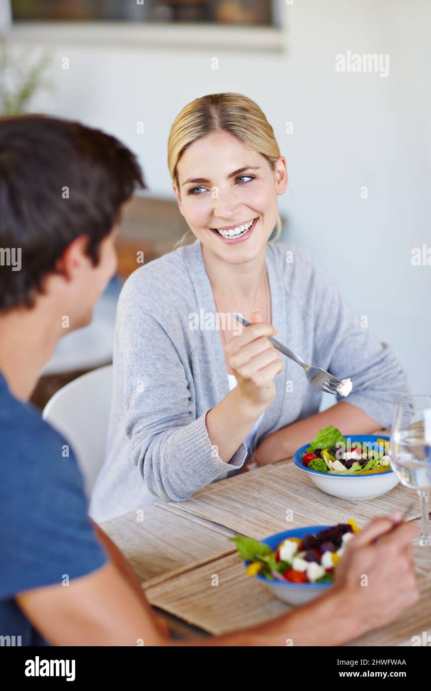 Une alimentation saine pour passer une saine pour toujours ensemble. Photo d'un jeune couple heureux en dégustant une salade saine ensemble. Banque D'Images