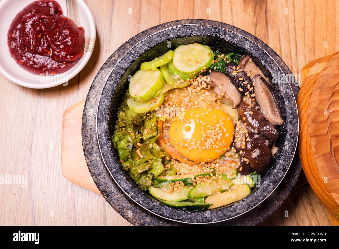Bibimbap dans un bol en pierre noir chauffé, plat traditionnel coréen -  bibimbap mélange de riz avec des légumes incluent le boeuf et l'oeuf frit,  la nourriture japonaise Hot pot Photo Stock -