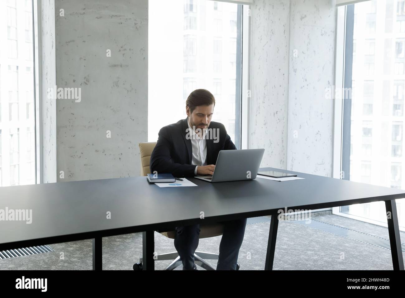 Jeune homme d'affaires caucasien concentré travaillant sur l'ordinateur. Banque D'Images