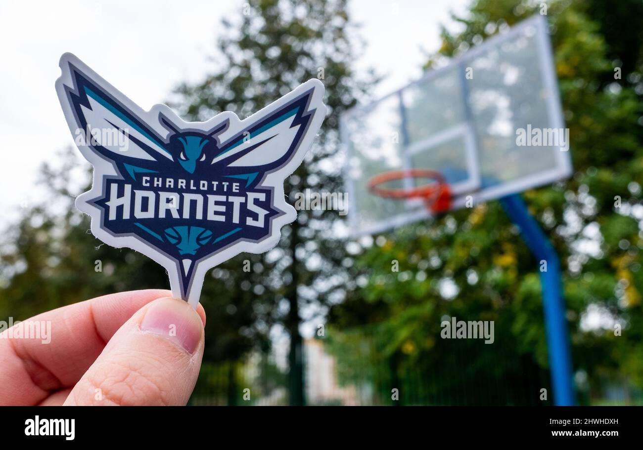 15 septembre 2021, Charlotte, USA, Un homme tient le logo du club de basket-ball  Charlotte Hornets dans sa main sur le terrain sportif Photo Stock - Alamy