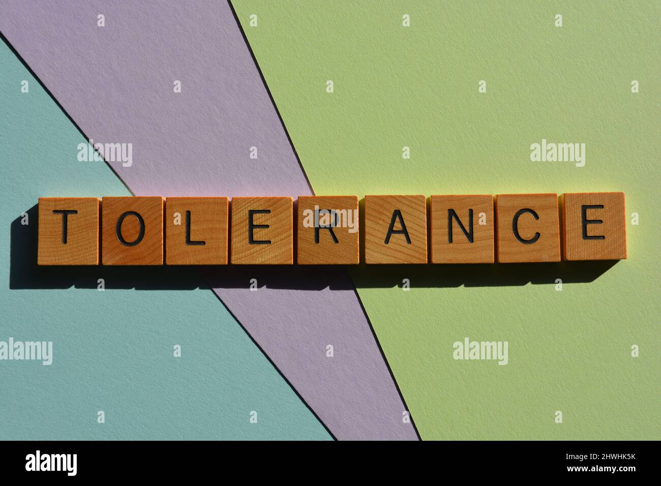 Tolérance, mot en lettres de l'alphabet bois isolées sur fond pastel avec espace de copie Banque D'Images