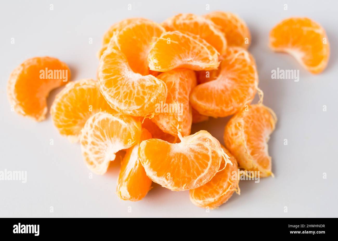 délicieuses tranches de mandarine pelées sur fond blanc Banque D'Images