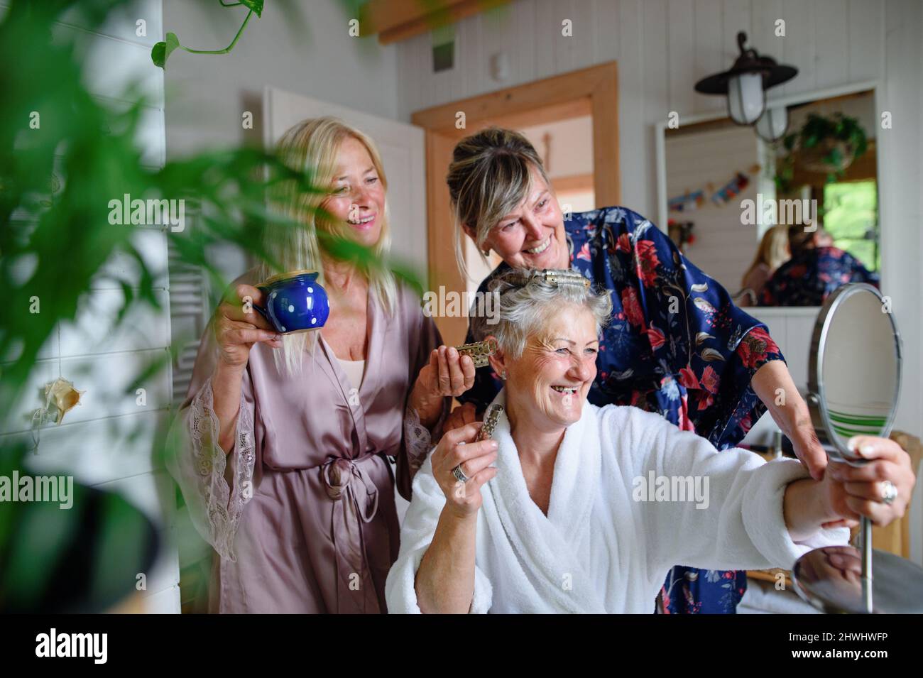 Des femmes âgées heureuses dans des peignoirs, s'amuser à l'intérieur dans la salle de bains, concept d'autosoin. Banque D'Images