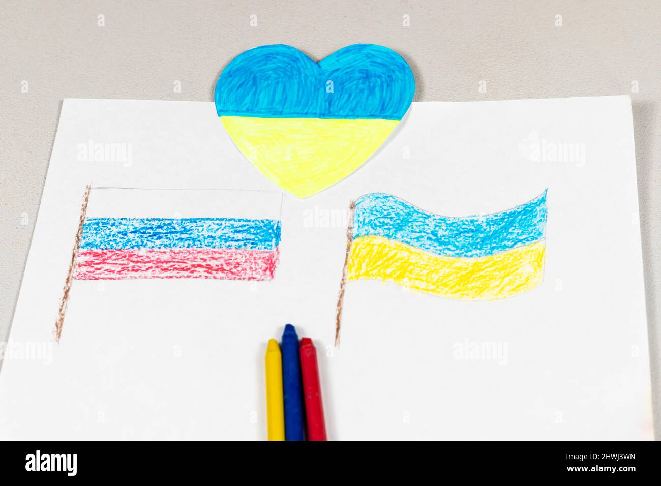 Gros plan sur les drapeaux de l'Ukraine et de la Russie et un coeur aux couleurs jaune-bleu. Enfants pour la paix. Les enfants dessinant pour la paix dans Banque D'Images