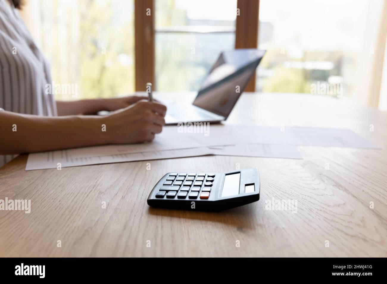 Gros plan image rognée comptable assis à table écrit sur papier Banque D'Images