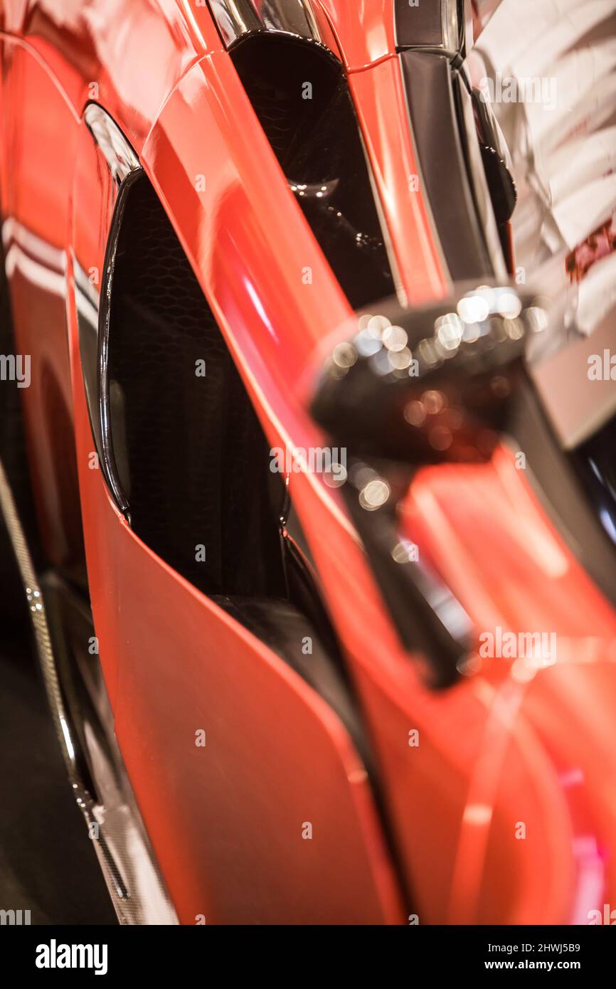 Carrosserie de voiture sport rouge, surface métallique du véhicule de course, concept de carrosserie de transport aérodynamique à grande vitesse, détail de la porte, de l'aile et de l'admission d'air. Banque D'Images