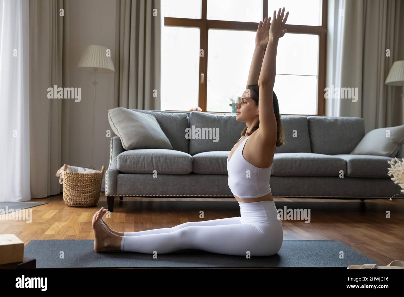 Jeune femme pratiquant le yoga à la maison, faisant le personnel Dandasana asana Banque D'Images