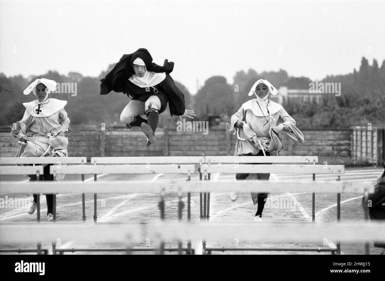 Les Jeux Olympiques de Nun. De gauche à droite Barbara Bremel, Kevin Moran et Susan Crosland pendant le tournage au terrain de sport polytechnique de Chiswick. Ils n'avaient pas tout à fait l'organisation, peut-être, des Jeux Olympiques de Munich. Mais les jeux ecclésiastiques hier avaient un esprit propre. Des nonnes, des moines, des rabbins et des vicars se sont rassemblés à Chiswick pour exposer leurs prouesses pour Spike Milligan , dont la nouvelle série télévisée de la BBC « A Milligan for all seasons » commence la semaine prochaine. Il y avait des courses de haies pour les religieuses (dont au moins deux étaient des conteurs), des voûtes de poteau pour les prêtres . . . et une confession étonnante Banque D'Images