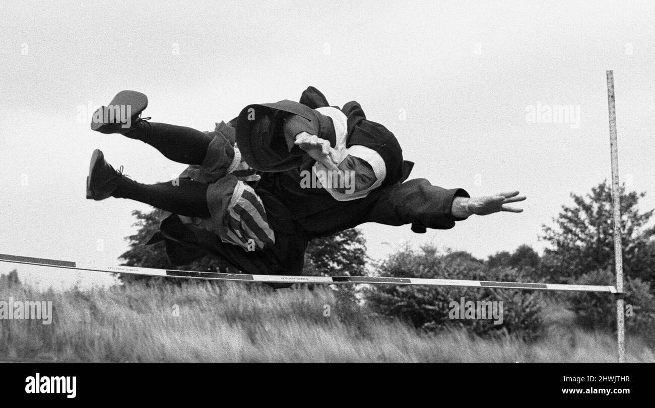 Les Jeux Olympiques de Nun. Le saut de la nonne, une tentative de David Cannon. Ils n'avaient pas tout à fait l'organisation, peut-être, des Jeux Olympiques de Munich. Mais les jeux ecclésiastiques hier avaient un esprit propre. Des nonnes, des moines, des rabbins et des vicars se sont rassemblés à Chiswick pour exposer leurs prouesses pour Spike Milligan , dont la nouvelle série télévisée de la BBC « A Milligan for all seasons » commence la semaine prochaine. Il y avait des courses de haies pour les religieuses (dont au moins deux étaient des conteurs), des voûtes de poteau pour les prêtres . . . et un incroyable relais confessionnel, avec chaque coureur s'arrêtant pour confesser tous les 100 mètres. PR Banque D'Images