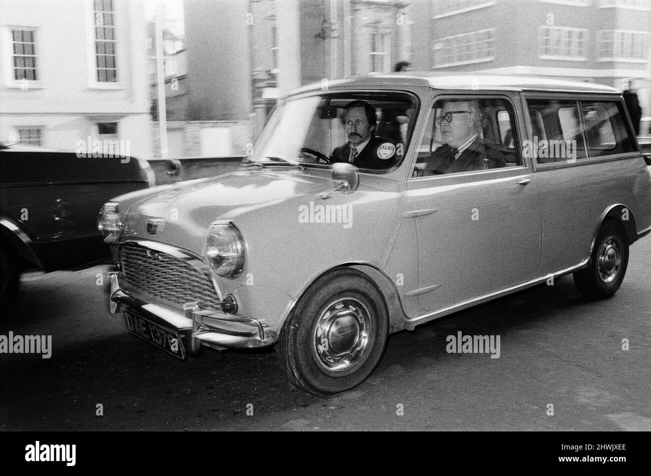 M. Geoffrey Rippon étant conduit dans son mini-chauffeur électrique. Ils font un petit tour autour du bloc avant de boire au 10 Downing Street. M. Geoffrey Rippon, ministre de l'Environnement, a pris aujourd'hui la livraison d'un mini-appareil électrique dans les bureaux du ministère de la rue Marsham. Son premier voyage officiel dans le mini-voyageur conduit par un chauffeur a été à Downing Street pour voir le Premier ministre, où (dans un autre cadre de cet ensemble) Mme Thatcher qui venait d'arriver dans sa grande limousine a pris un moment de pause alors qu'elle a vu le mini arriver à Downing Street. Photo prise le 21st novembre 1973 Banque D'Images