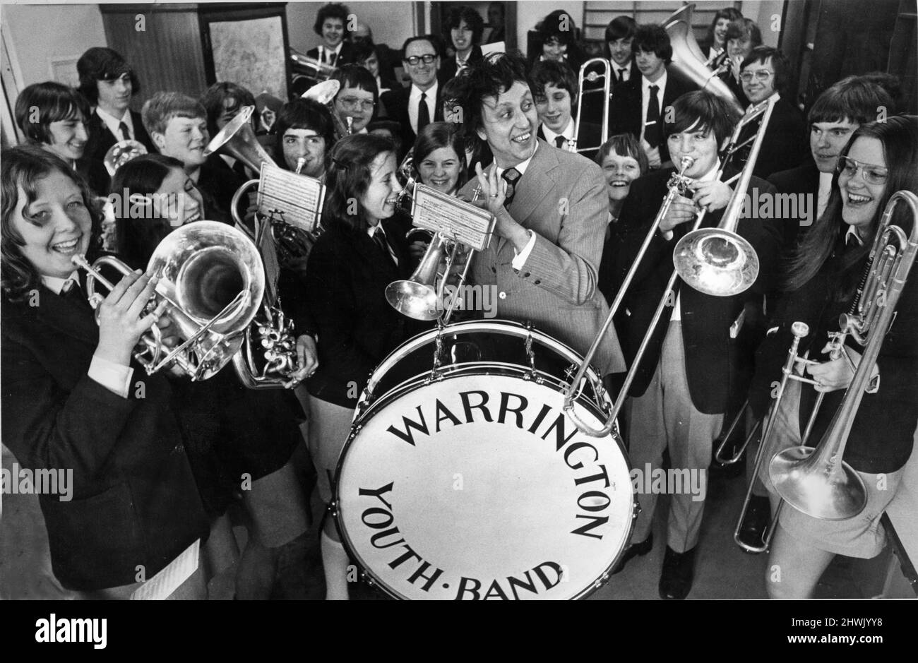 Ken Dodd - comédien de Liverpool. Ken avec trombone, jouant avec le Warrington Youth Band de Cheshire. Sir Kenneth Arthur Dodd, OBE (né le 8 novembre 1927) est un comédien anglais, chanteur-compositeur et acteur, identifié par ses cheveux indisciplinés et ses dents saillantes, son rouge, blanc et bleu 'bâton de chatouillement' et son salut optimiste de 'Comment j'ai tické!'. Il a également créé les personnages de The Diddy Men (« Diddy » étant un mot britannique informel pour « small »). Photo prise le 12th avril 1973 Banque D'Images