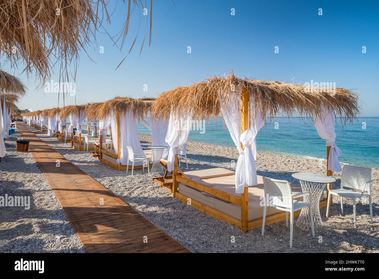 Lits de plage à baldaquin avec rideaux blancs sur une plage vide en été. Banque D'Images