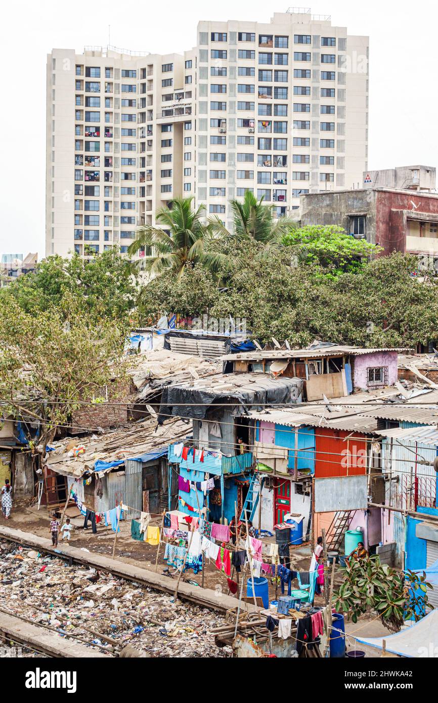 Mumbai Inde, Dharavi Shahu Nagar, bidonvilles shanties pauvreté pauvre caste hindoue basse, déchets bas revenus déchets ghetto maisons, moderne bâtiment élevé d'appartements Banque D'Images