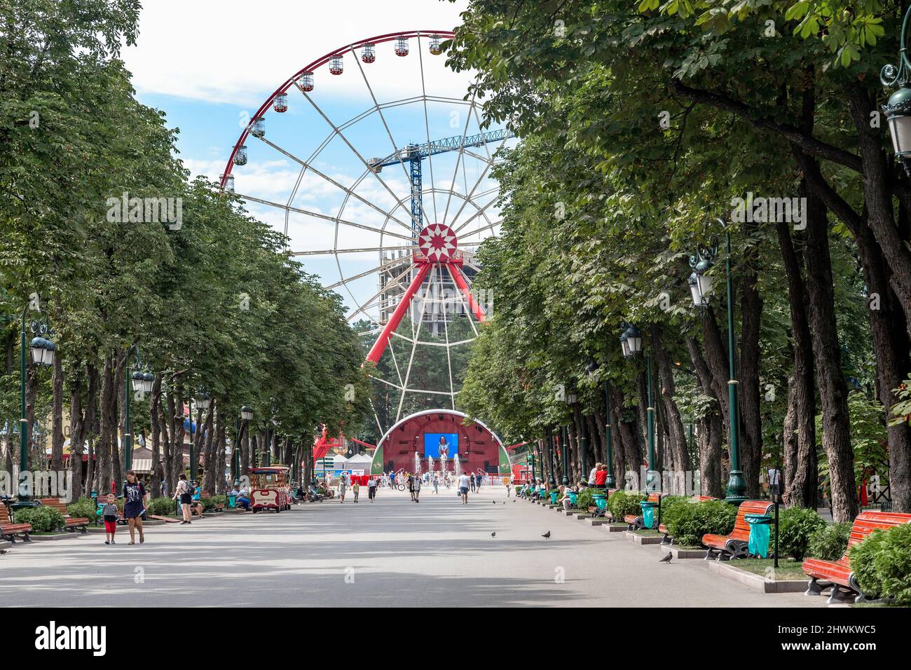KHARKIV, UKRAINE - 3 AOÛT 2021 : c'est la principale allée avec une grande roue dans le Parc central de la Culture et des Loisirs. Banque D'Images