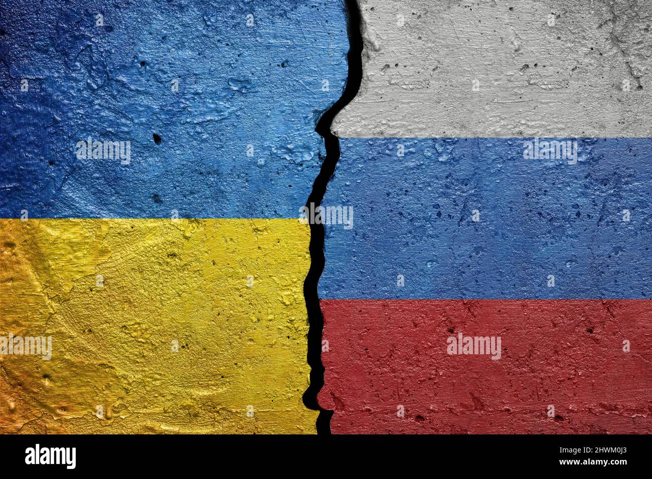 Ukraine et Russie - mur en béton fissuré peint avec un drapeau ukrainien à gauche et un drapeau russe à droite Banque D'Images