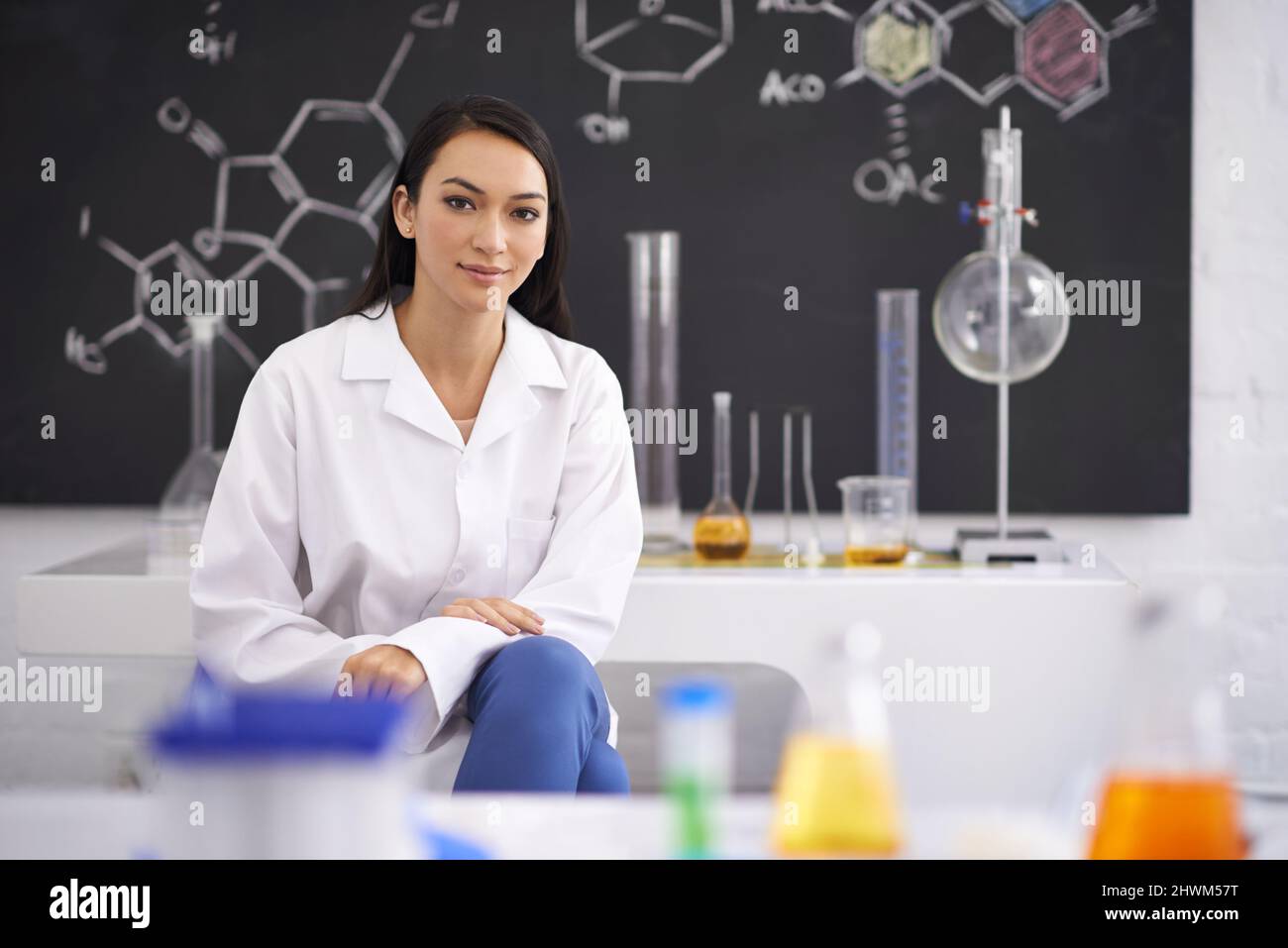 Tous les outils dont elle a besoin pour réussir. Portrait d'une scientifique assise dans un laboratoire. Banque D'Images
