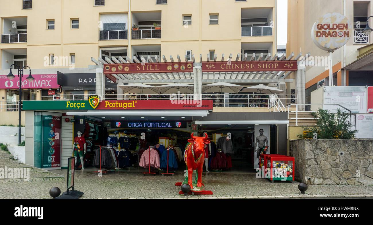 Un magasin de sport Forca Portugal et d'autres magasins de détail, dont un restaurant chinois le long du quai à Vilamoura, Portugal. Banque D'Images