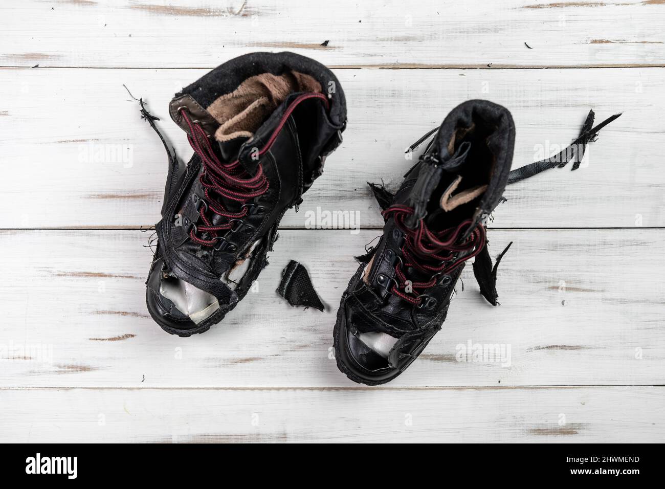 Chaussures usées déchirées bottes.Arrière-plan en bois clair.Chaussures  déchirées et cassées Photo Stock - Alamy