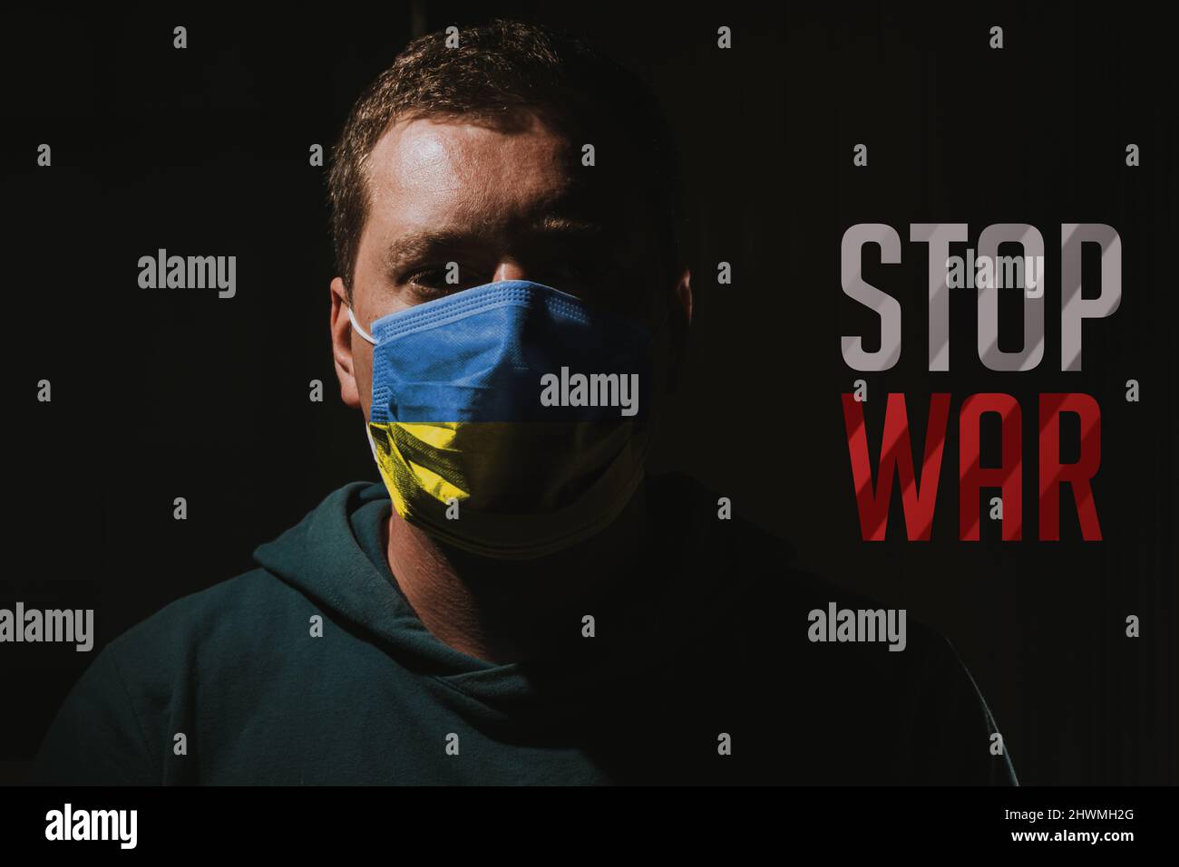 Homme avec Ukraine masque de drapeau avec texte arrêter la guerre Banque D'Images