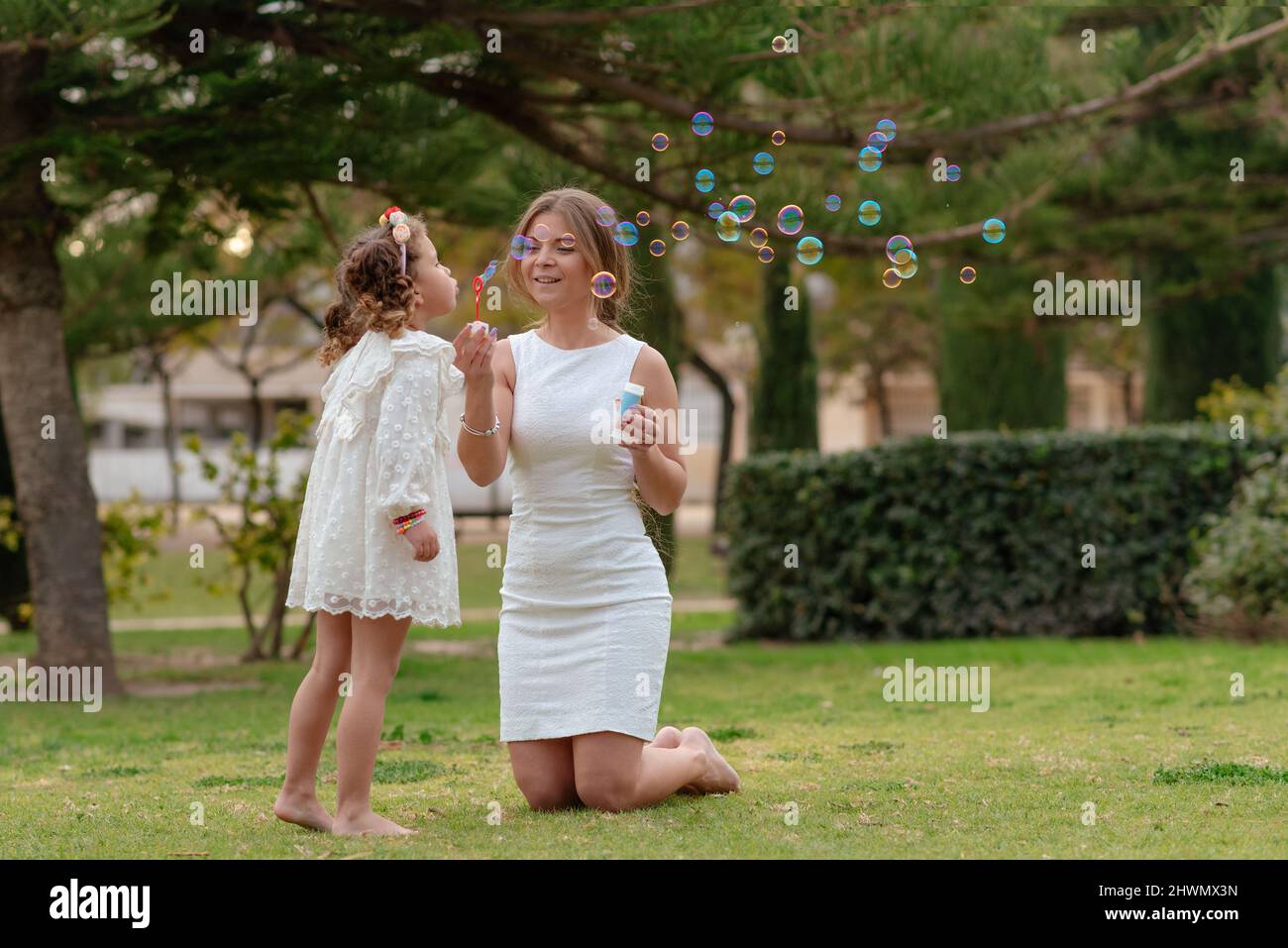 mère et fille soufflent des bulles de savon à l'extérieur Banque D'Images