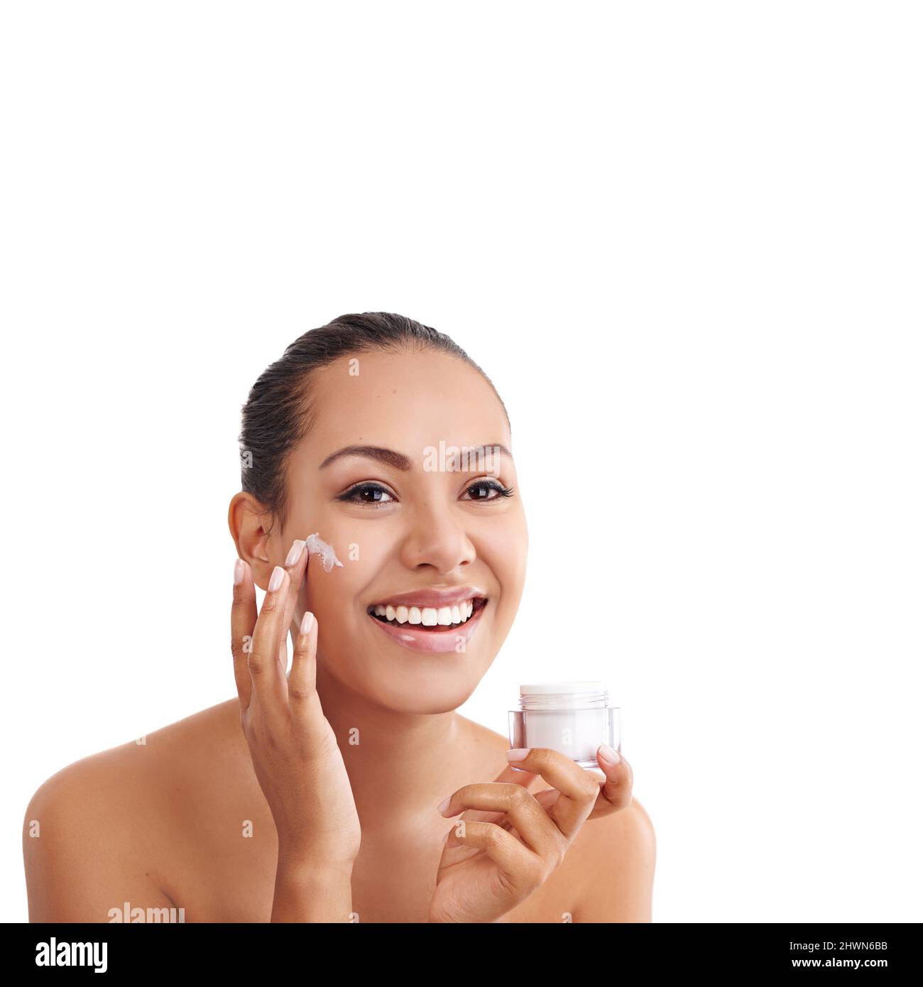 Ajouter une touche d'humidité. Photo studio d'une belle jeune femme appliquant un hydratant sur sa peau. Banque D'Images