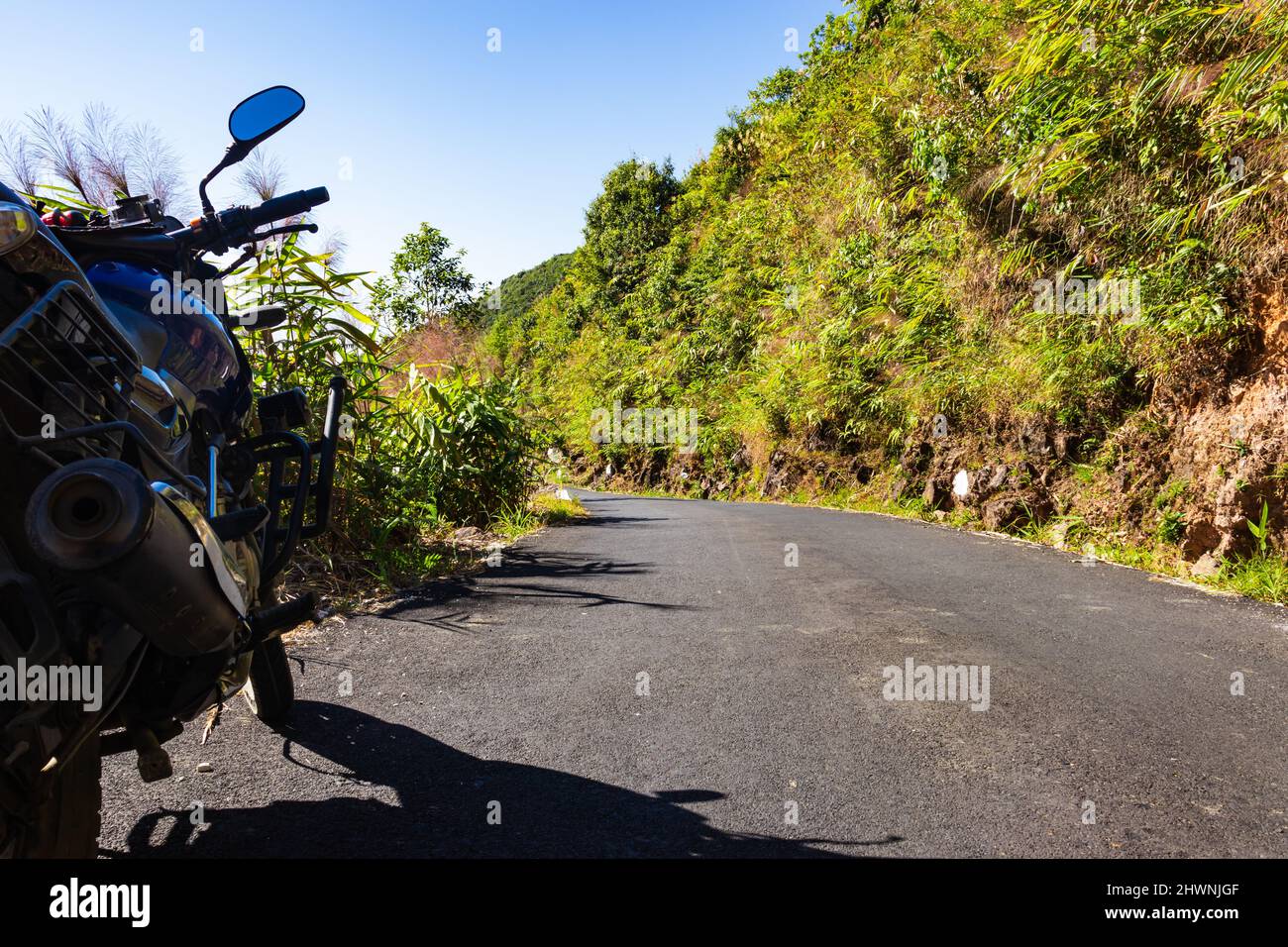 route tamac de montagne isolée avec moto et ciel bleu vif au matin image est prise à meghalaya inde. Banque D'Images