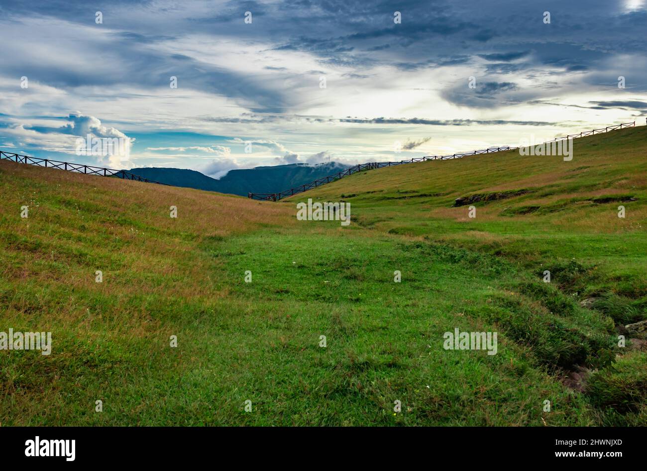 campagne herbe verte montagne avec ligne de tête et ciel nuageux le matin Banque D'Images