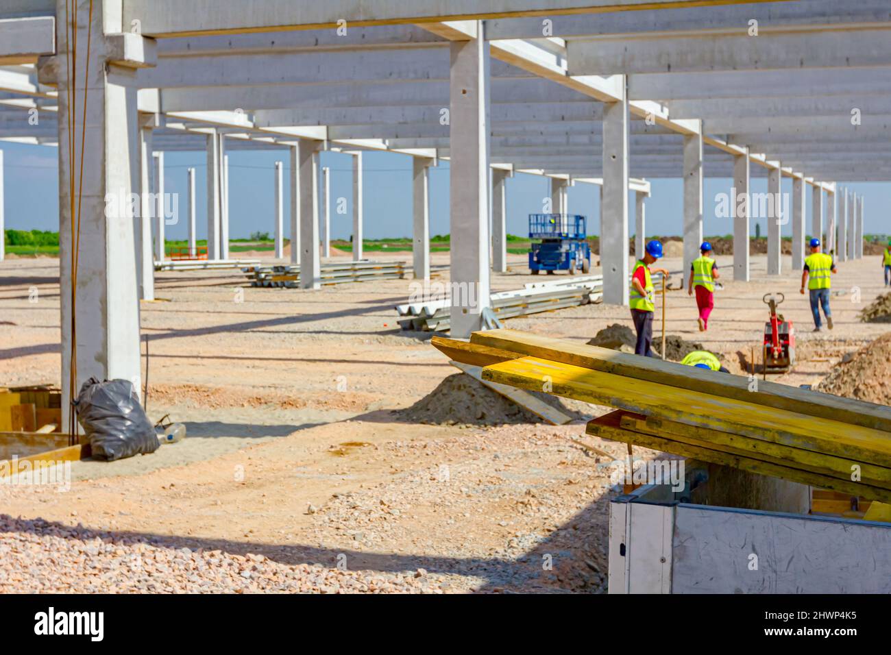 Des planches en bois peintes et empilées sont placées dans une remorque de camion sur le chantier de construction. Les fauteurs, les travailleurs sont des moules longs d'assemblage pour le béton. Banque D'Images