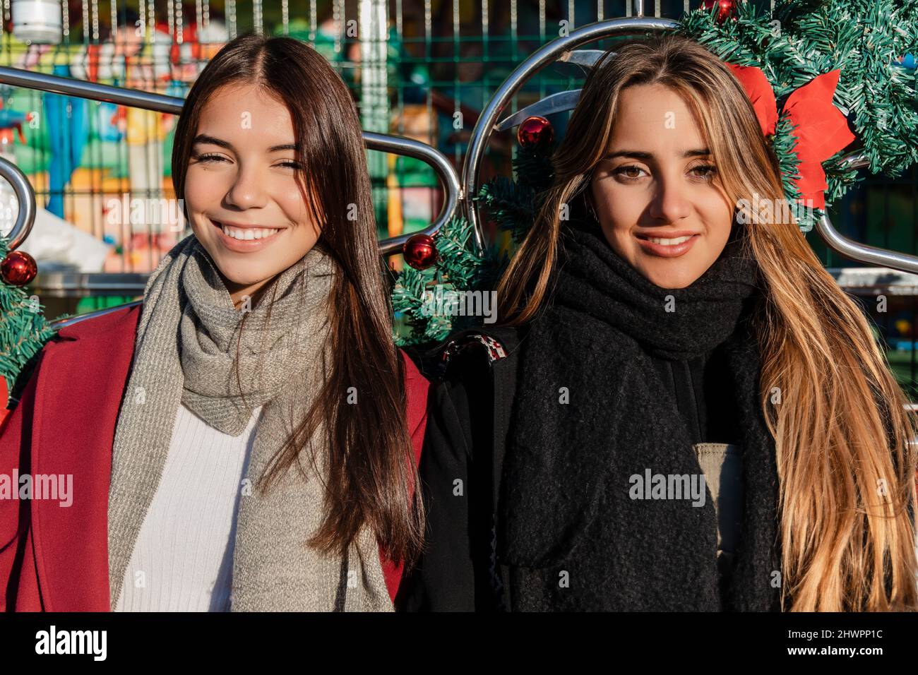 Jeunes amis souriants aux cheveux longs portant des vêtements chauds par temps ensoleillé Banque D'Images