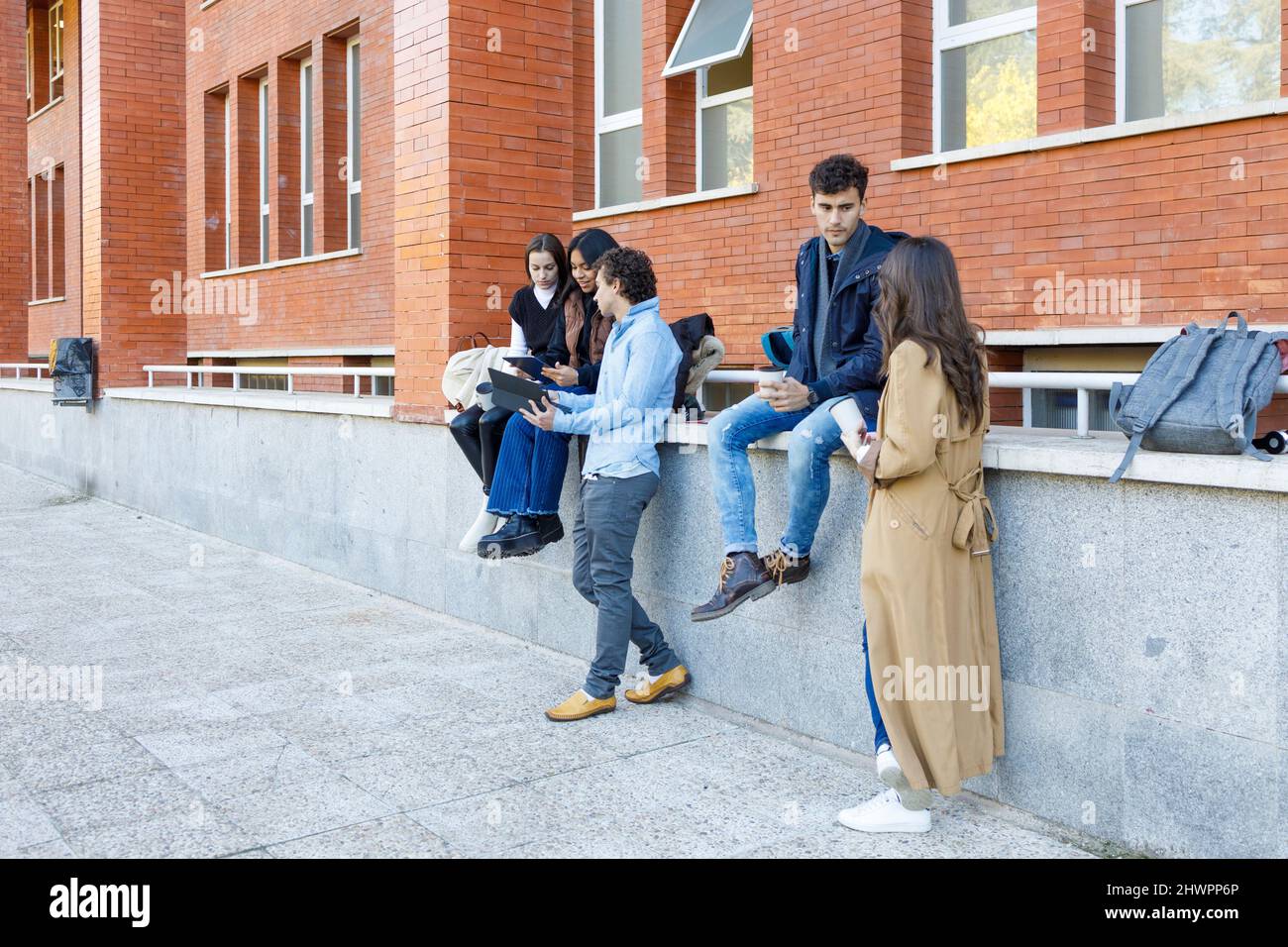 Les étudiants multiraciaux discutent de projet par construction d'université Banque D'Images