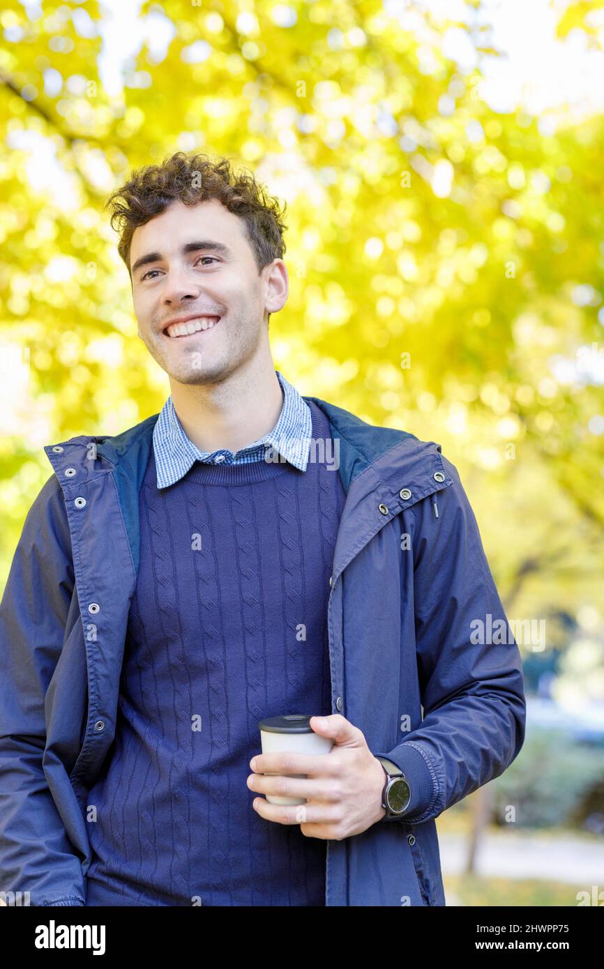 Contemplatif avec une tasse à café jetable sur le campus de l'université Banque D'Images