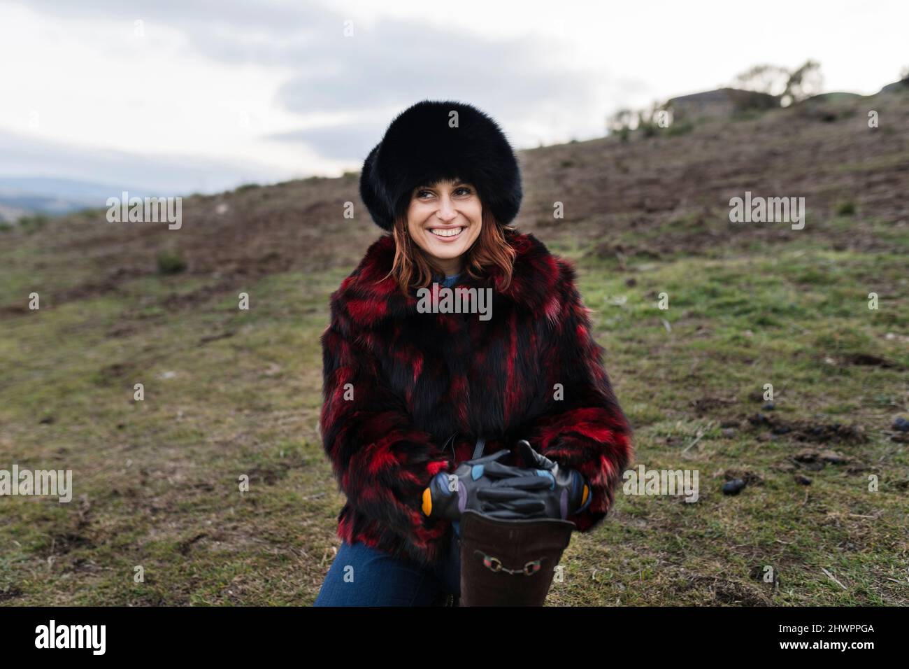 Femme souriante portant un chapeau de fourrure au ranch Banque D'Images